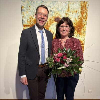 Samtgemeindebürgermeister Henning Fricke übergibt Elke Denkamp zur Abschiedung ein Geschenk